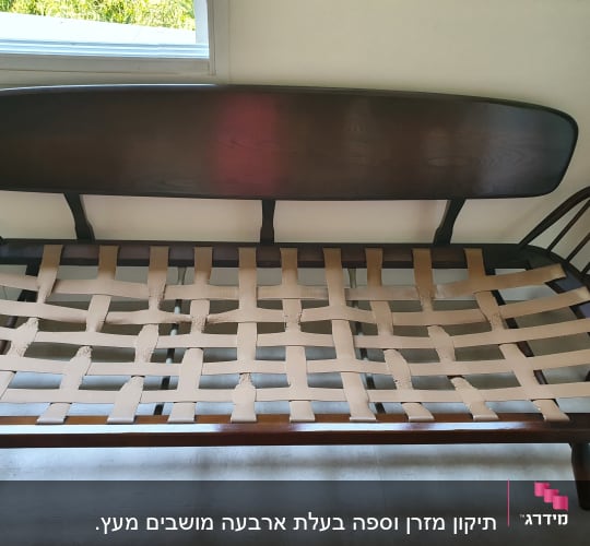 רצועות בד חומות שזורות על מסגרת עץ של ספה
